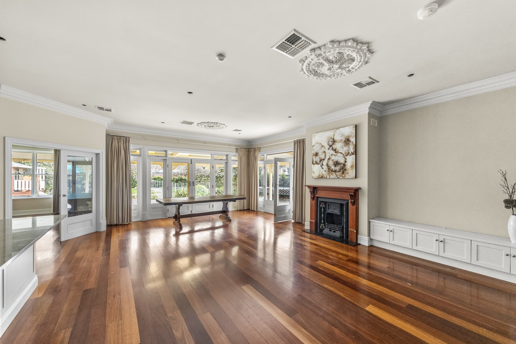 Renovated formal living room with polished timber floors, ceiling rose and open fireplace